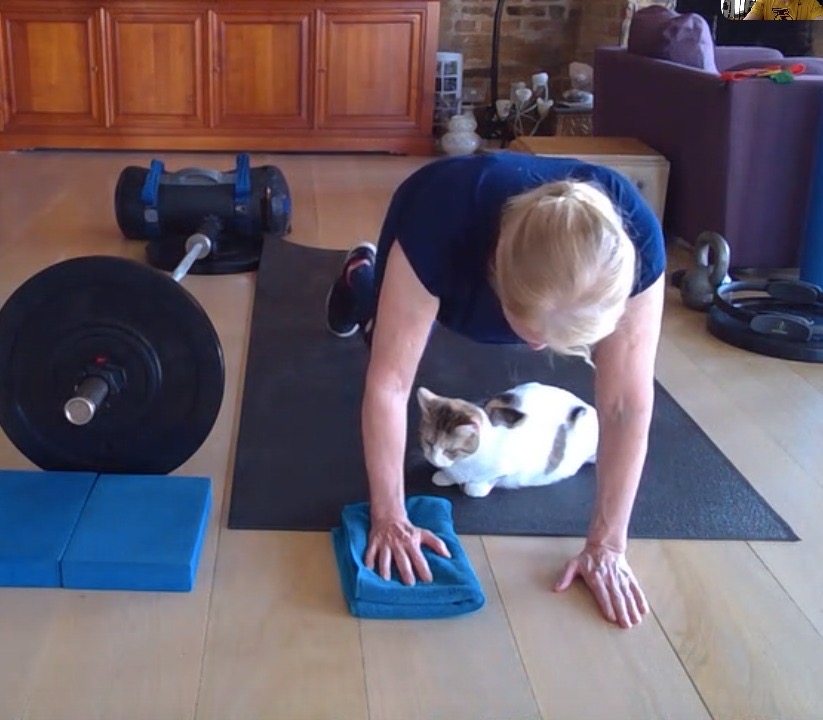 Cathy doing Yoga with Pippa the cat on her mat